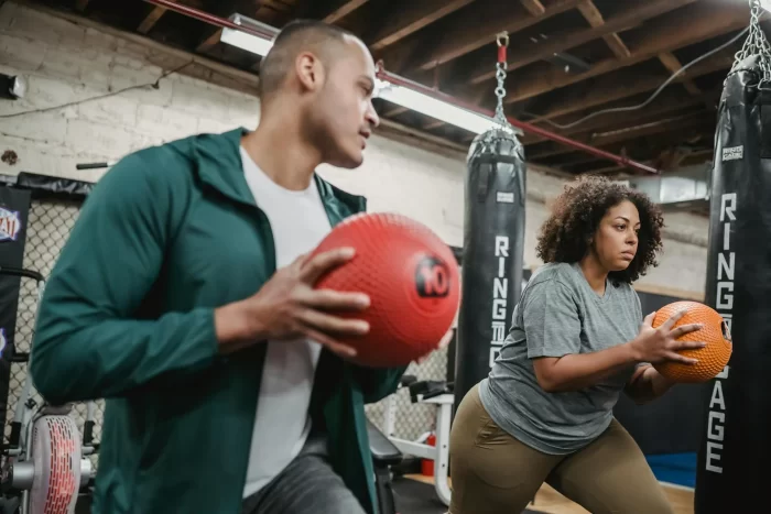 Black overweight woman with trainer with ball in hand